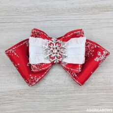 red and white snowflake themed bow with silver accents and center silver snowflake pin